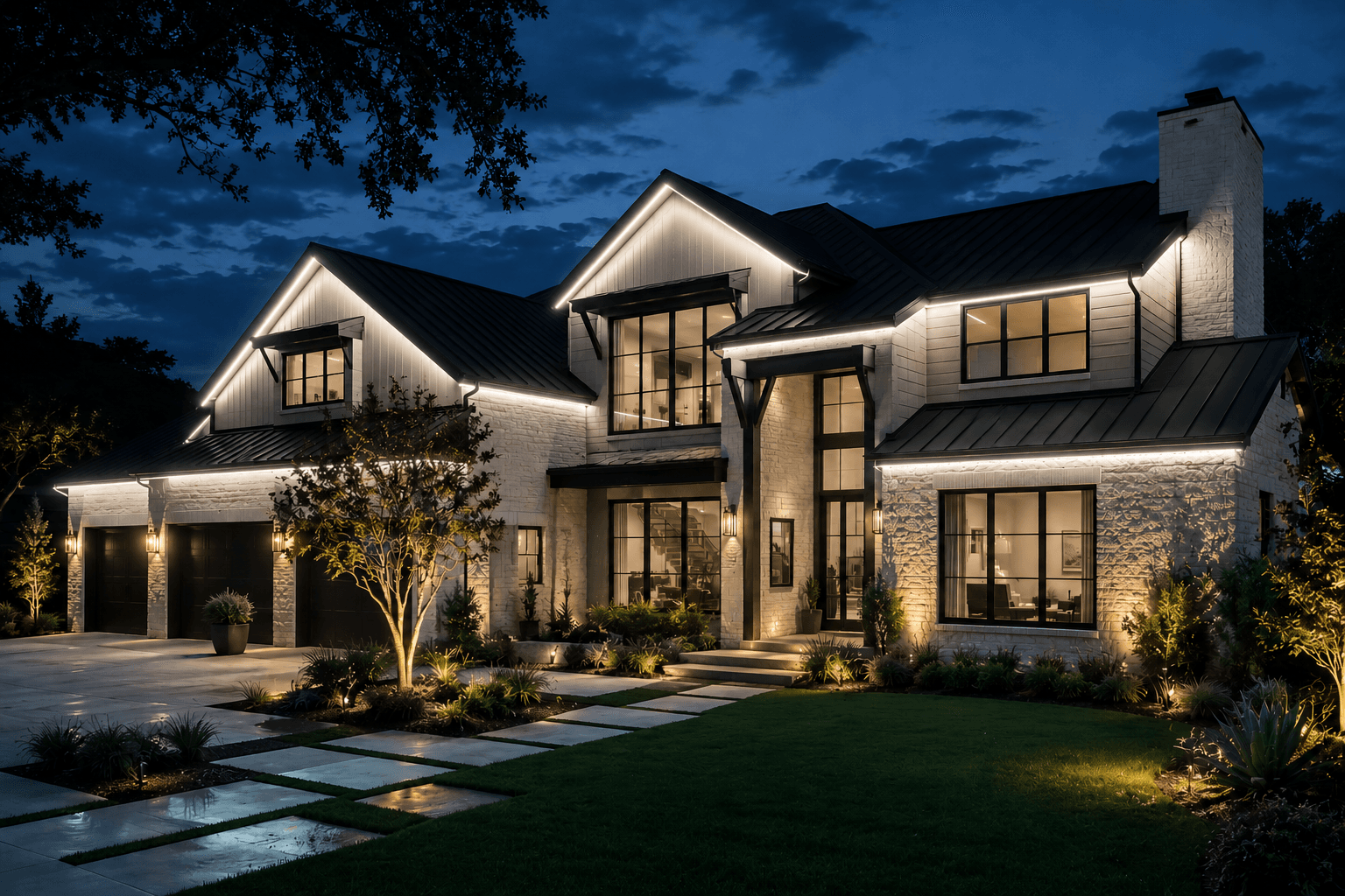 Modern white farmhouse with black trim and glowing exterior lighting under a dark night sky.
